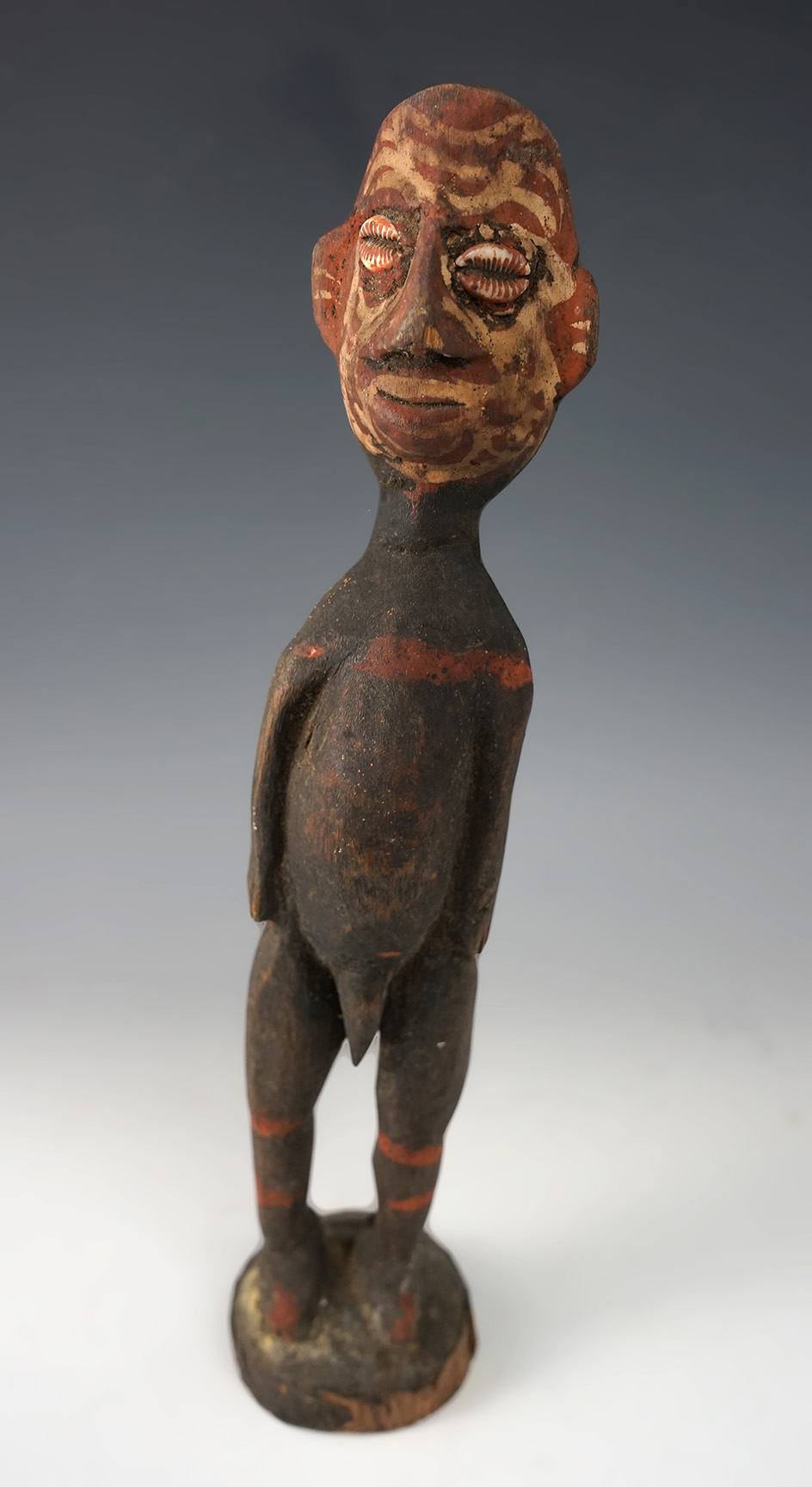 11 1/2" Tall carved wood African human figure that retains the original shell eyes.