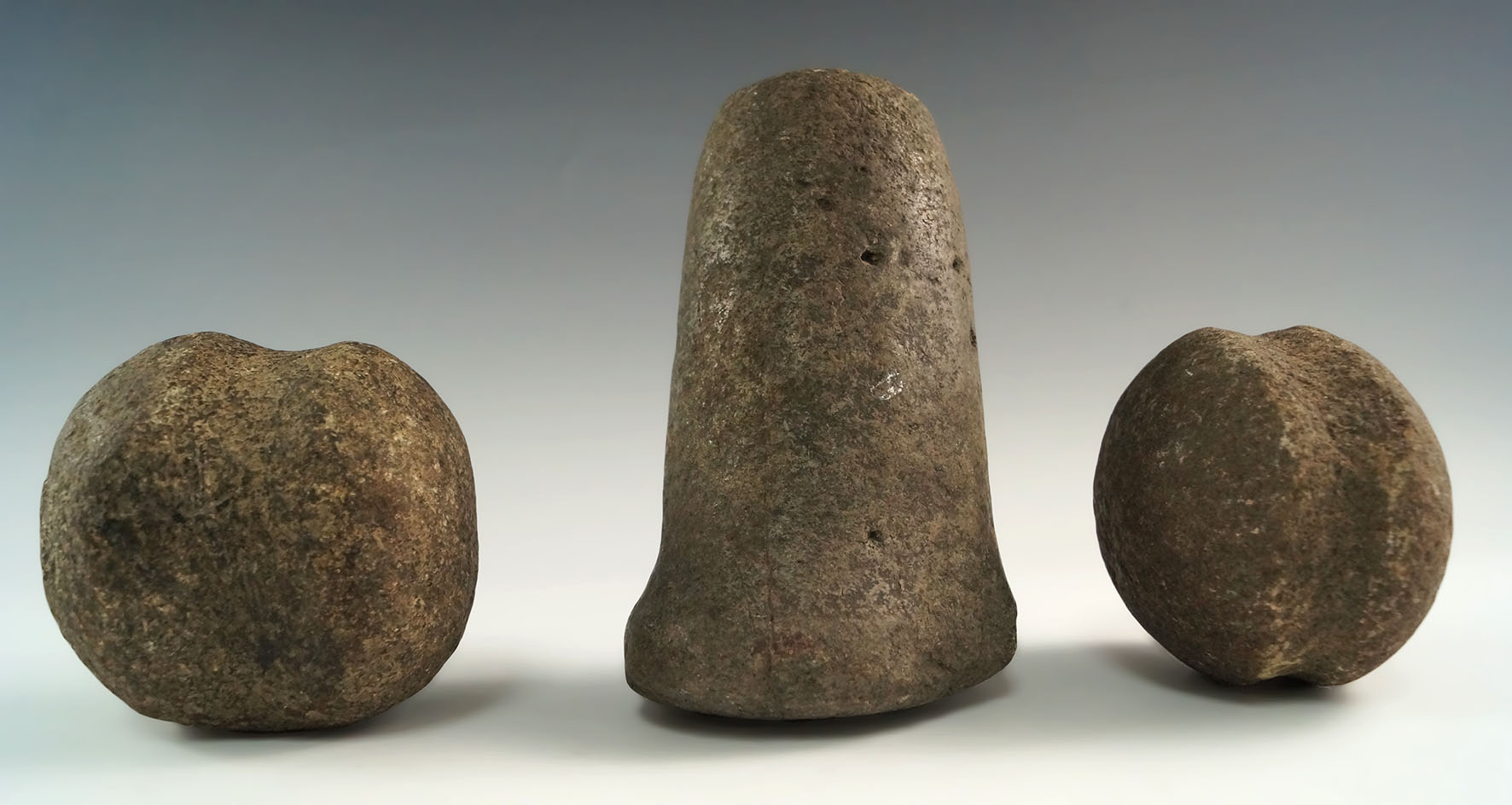 Set of three stone tools found in Ohio including a grooved weight, a Hammerstone and a pestle.