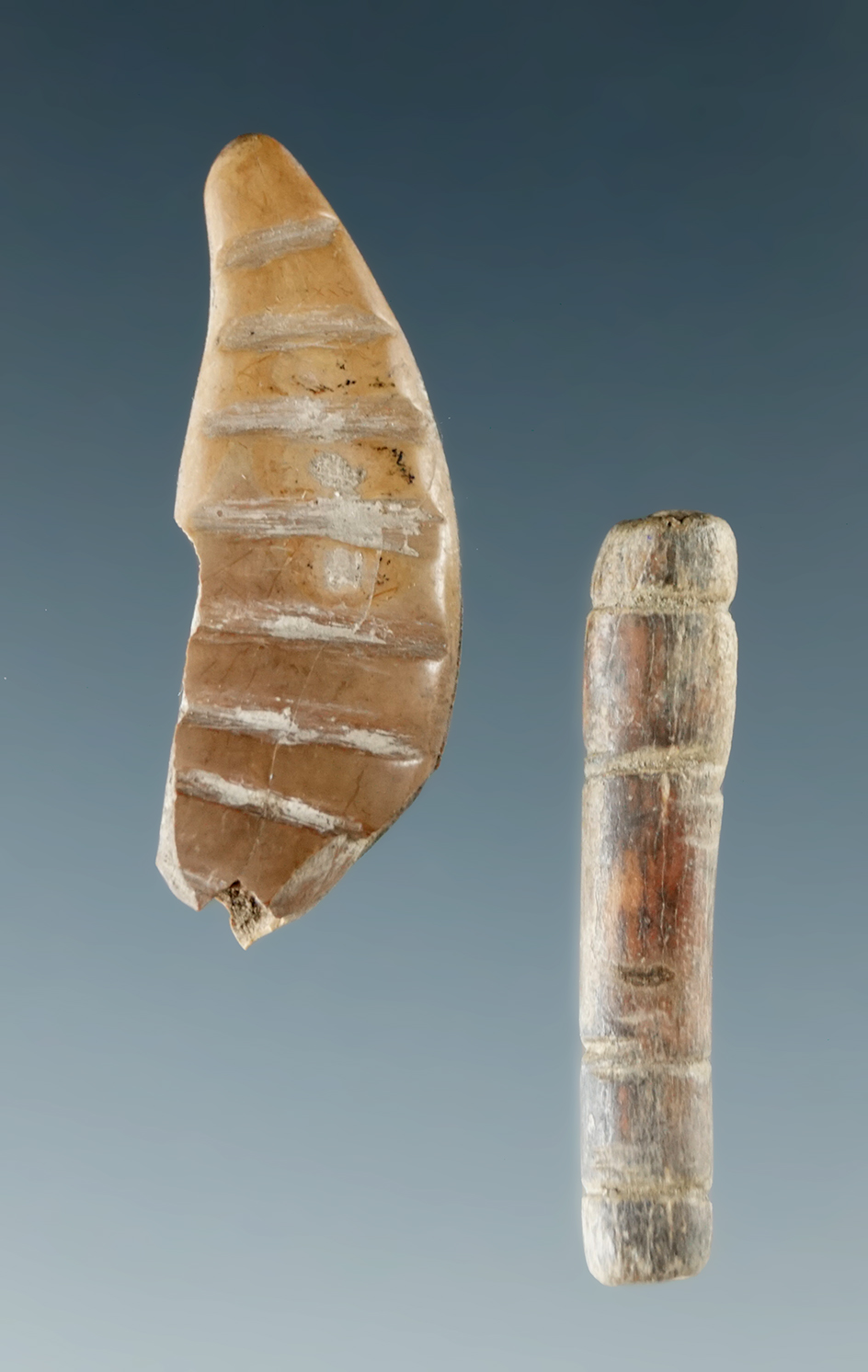 2 carved ornamental items including a 1" engraved bone tube bead and a 1 1/16" engraved tooth.