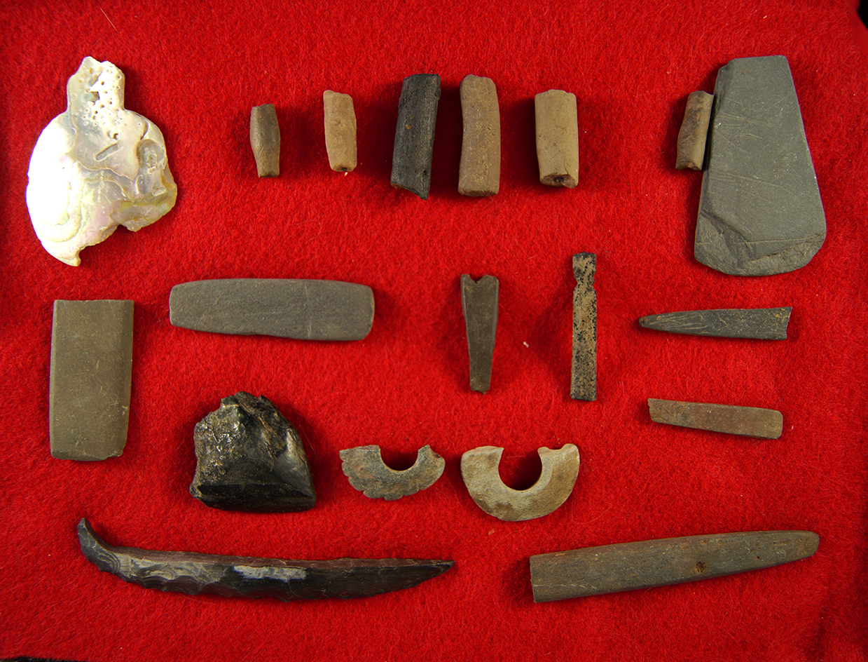 Group of Stone and Shell artifacts, including pendant pieces, beads, and broken bases of pipes.