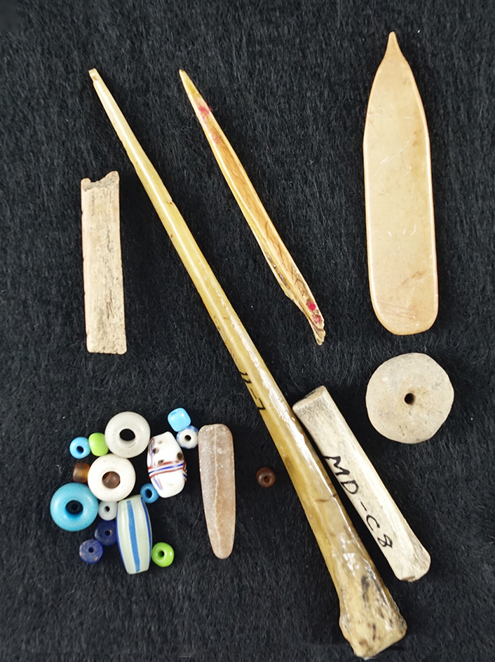 Group of historic trade beads, stone beads and bone artifacts found in Kansas. Largest is 5".