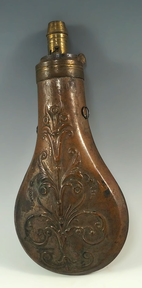 7" tall brass powder flask with a floral design from the mid 1800s.
