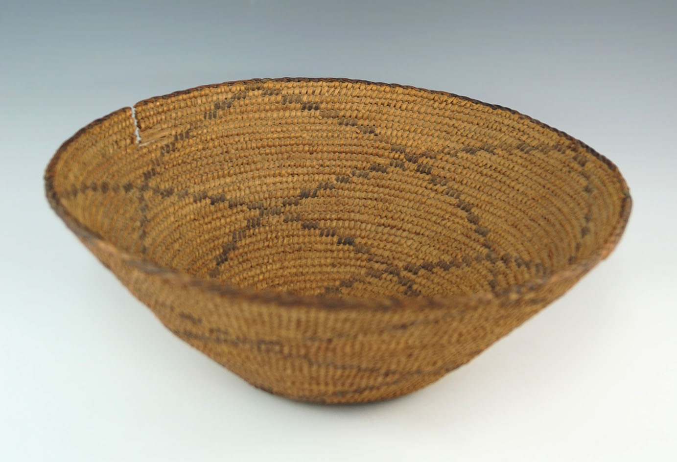 Old tightly woven 11" diameter basket with one small tear but otherwise excellent condition.