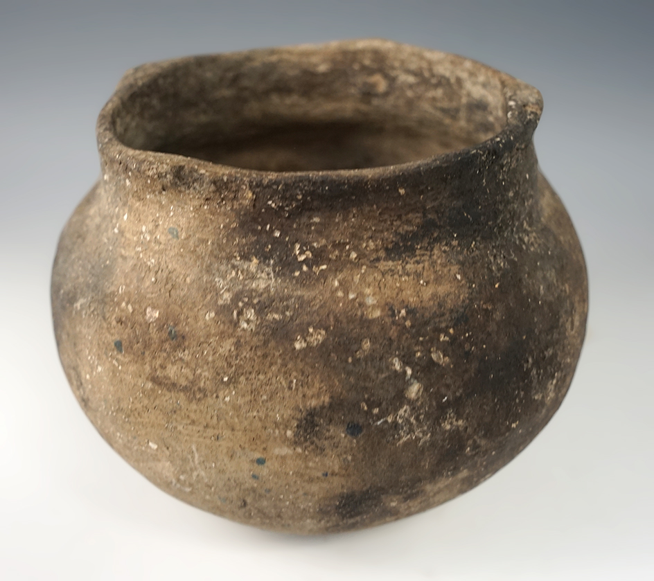 4 1/4" tall x 5" wide shell tempered clay pottery vessel found in Arkansas. Solid condition.