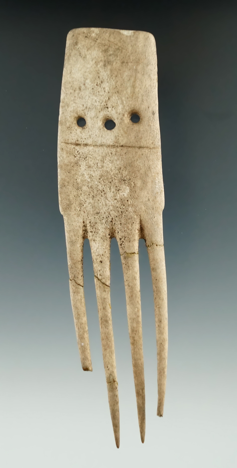 5 1/2" well styled antler comb with 3 holes. Tines have been reglued but are original. New York.