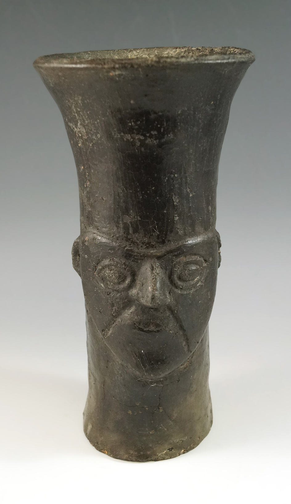 Pre-Columbian Inca Kero made from fired clay with a human face design. Stands 7 1/2" tall. Peru.