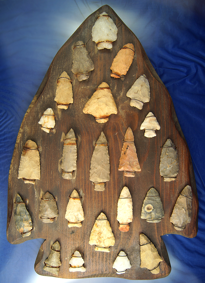 Frame of 24 southern arrowheads wired to an arrowhead shaped plaque.